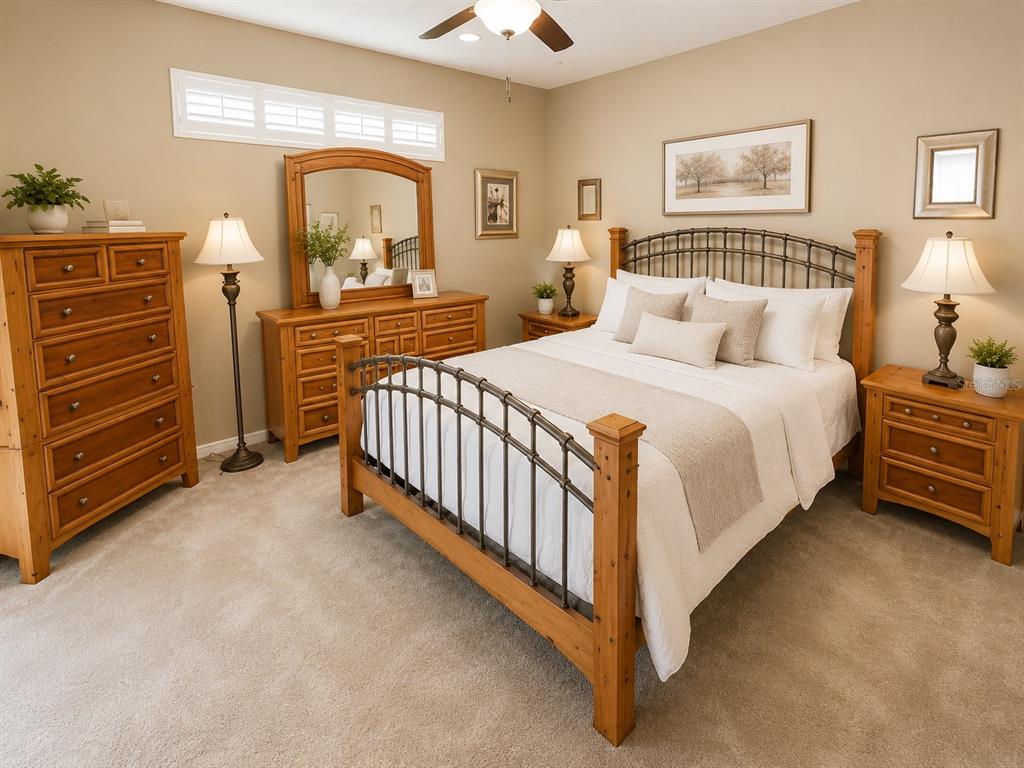 A bedroom features a wooden bed frame, matching dresser, nightstands, and beige carpeted flooring — 4428 HAVELOCKE DRIVE, LAND O LAKES, FL
