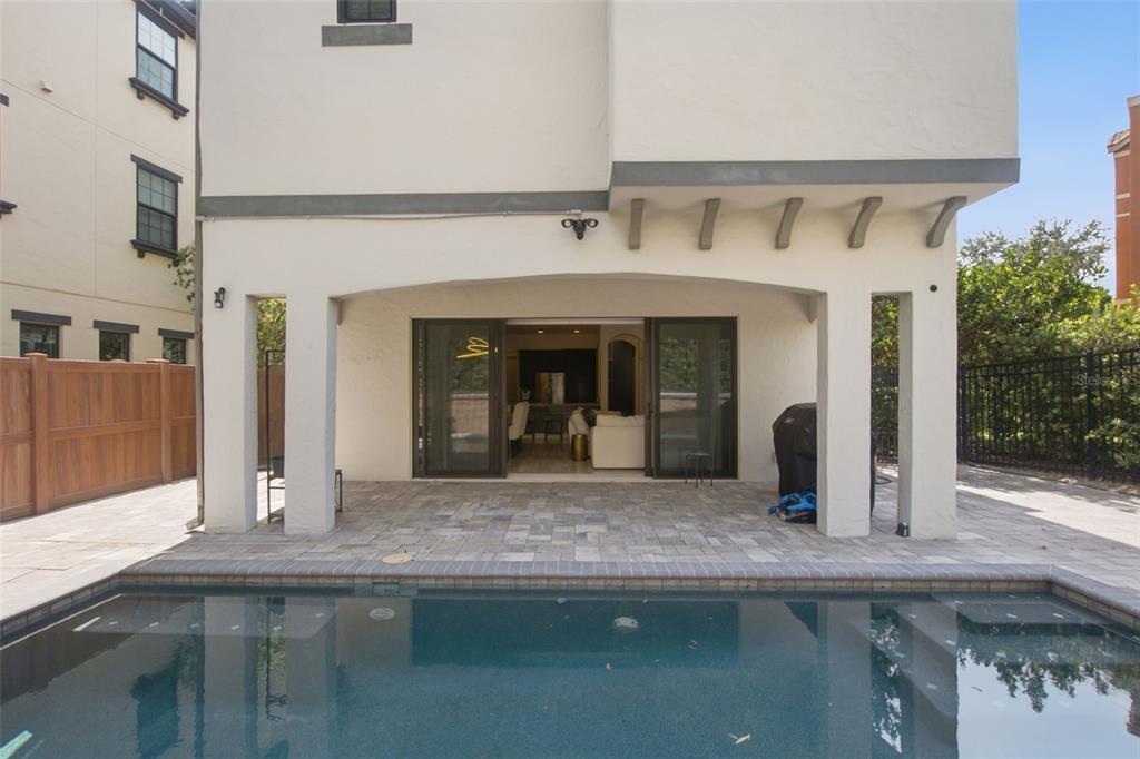 A covered balcony with black metal railings overlooks a residential street and nearby apartment buildings — 7689 TOSCANA BOULEVARD, ORLANDO, FL
