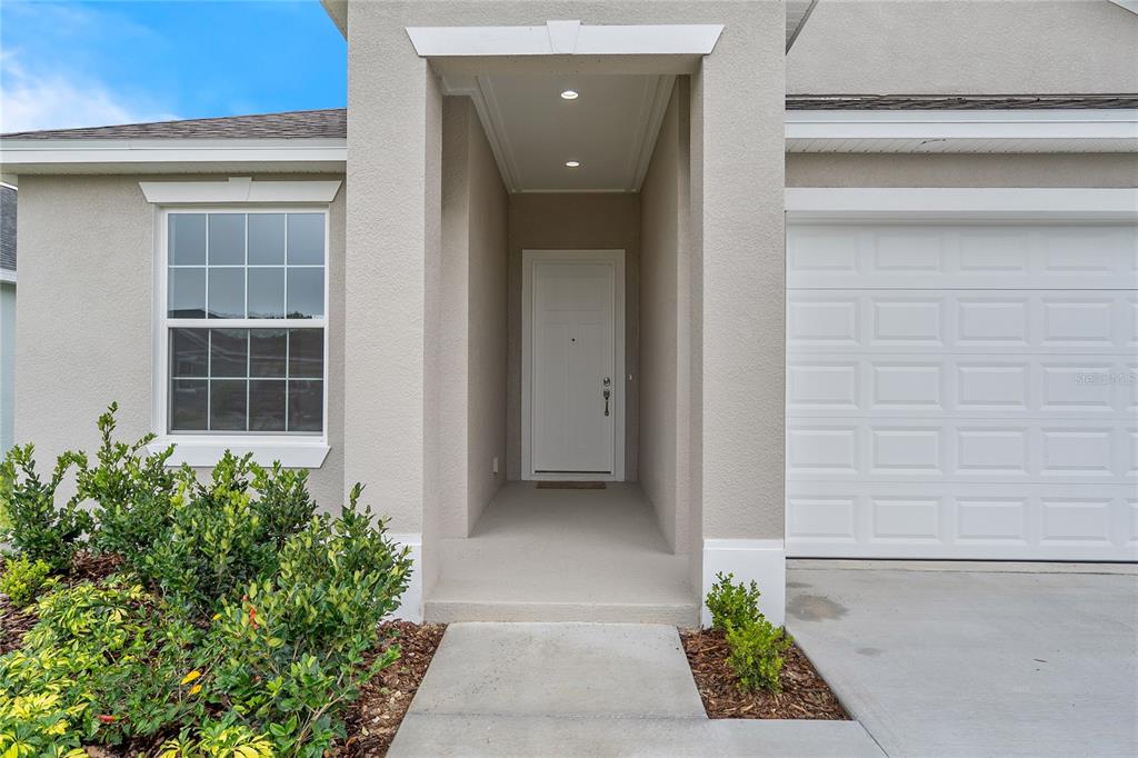 A beige single-story house features a three-car garage and a concrete driveway — 4541 FAIRWAY OAKS DRIVE, MULBERRY, FL