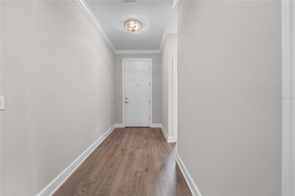 The exterior of a house features a white front door, a window, and a garage — 4541 FAIRWAY OAKS DRIVE, MULBERRY, FL