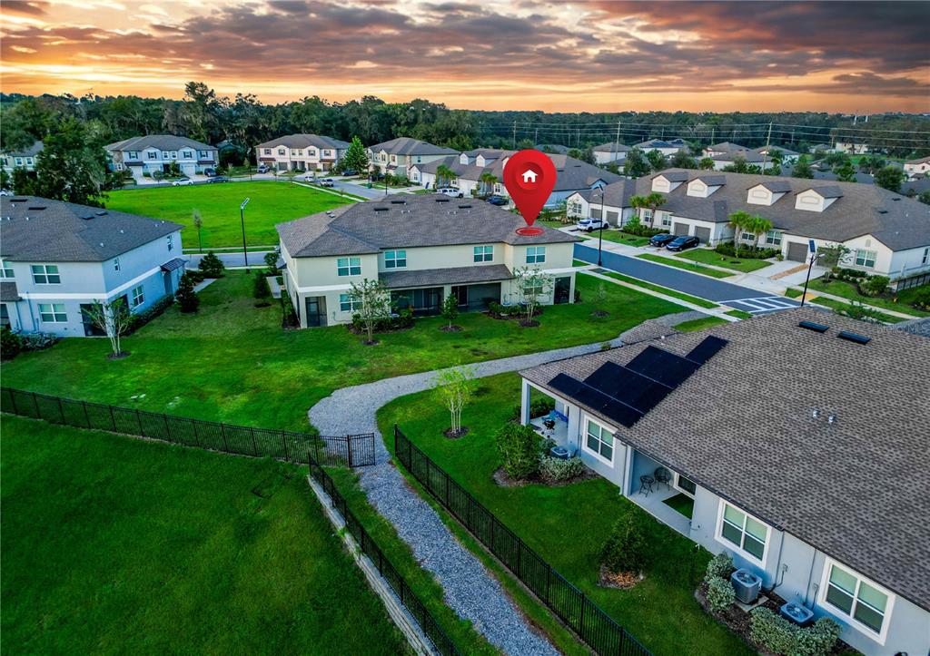An aerial view shows a two-story residential building with a red location pin — 7082 RIPPLE POND LOOP, ZEPHYRHILLS, FL