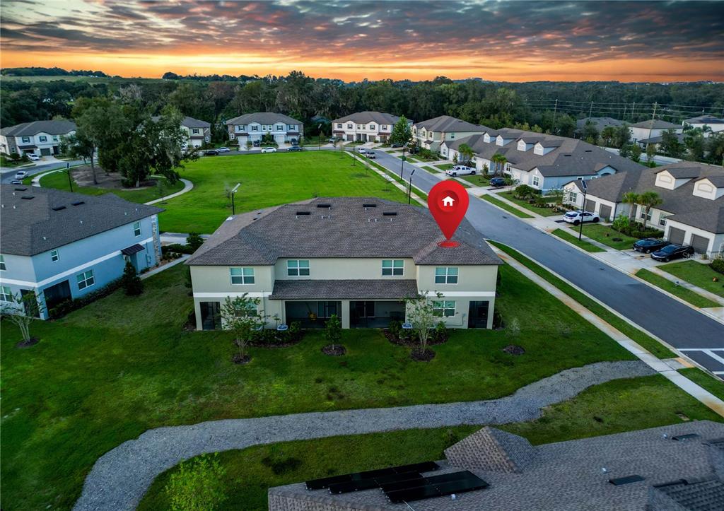 An aerial view shows a two-story townhouse with a red location pin on the roof — 7082 RIPPLE POND LOOP, ZEPHYRHILLS, FL
