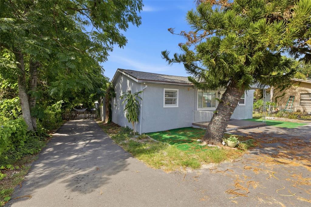 A gray single-story house with a paved driveway and a large tree in the front yard — 2706 E ANNIE STREET, TAMPA, FL