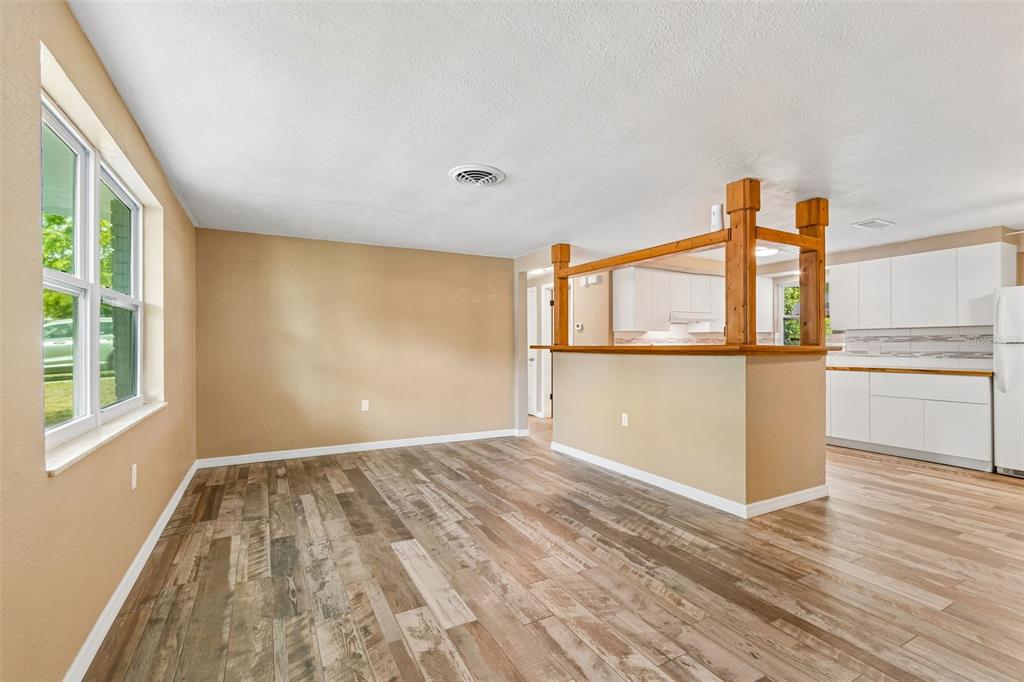 A single-story white brick house with a red front door and a covered porch — 5046 FARLEY DRIVE, HOLIDAY, FL