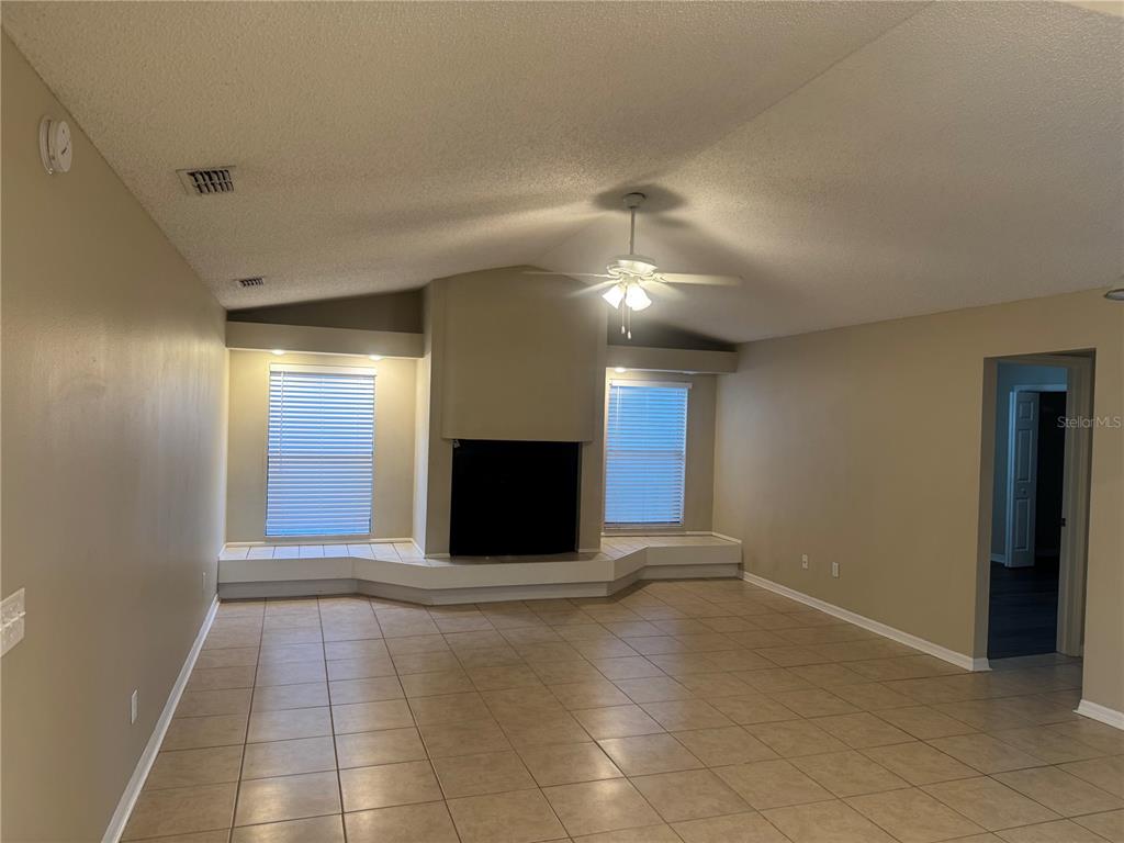 A living room with tile floors, a central fireplace, and two windows with built-in benches — 2537 ARBORWOOD DRIVE, VALRICO, FL