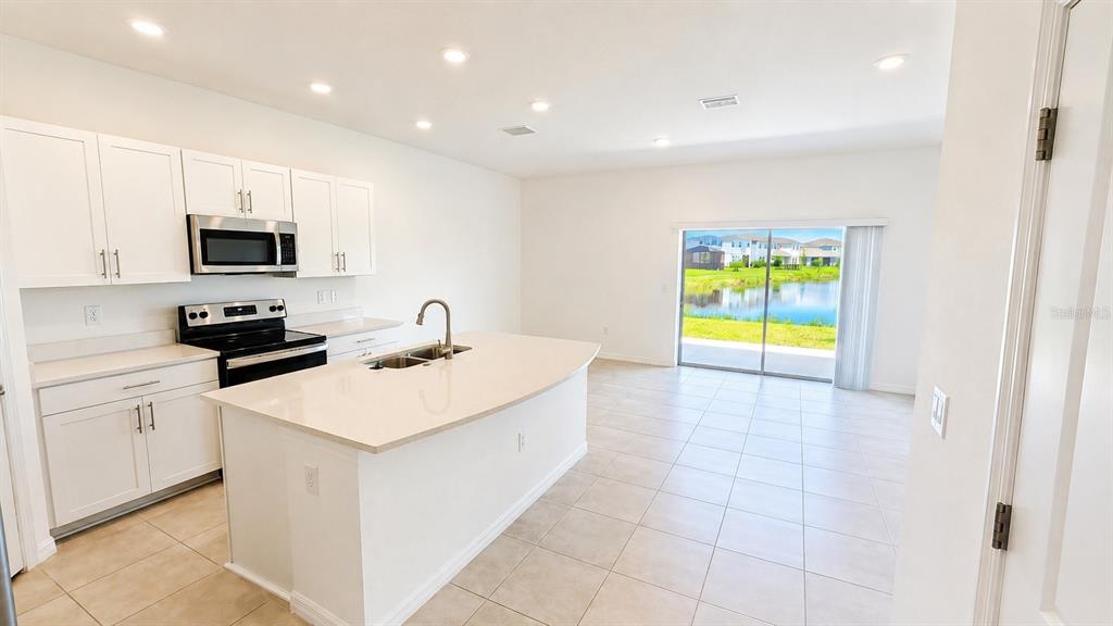 A kitchen with white cabinets, stainless steel appliances, and a large central island — 5686 ARCHIPELAGO STREET, NOKOMIS, FL