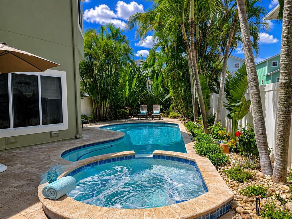A backyard pool and hot tub area with palm trees and lounge chairs — 140 50TH STREET, HOLMES BEACH, FL