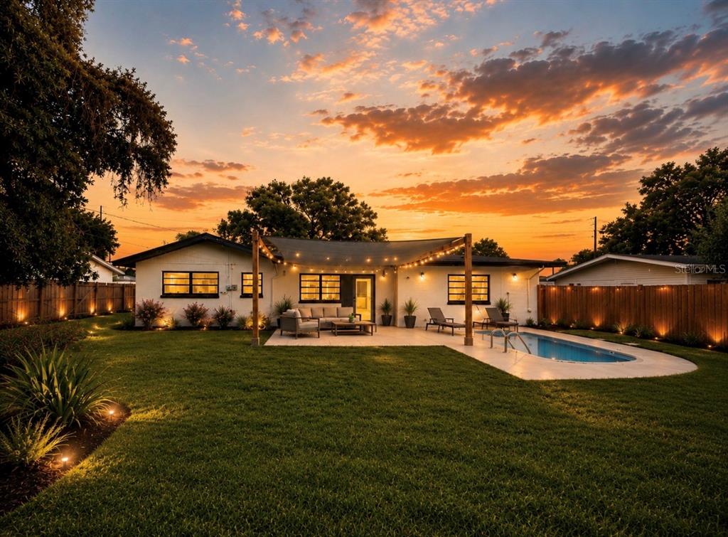 An aerial view shows a house with a gray roof, a pool, and a fenced yard — 3101 FLOWERTREE ROAD, BELLE ISLE, FL