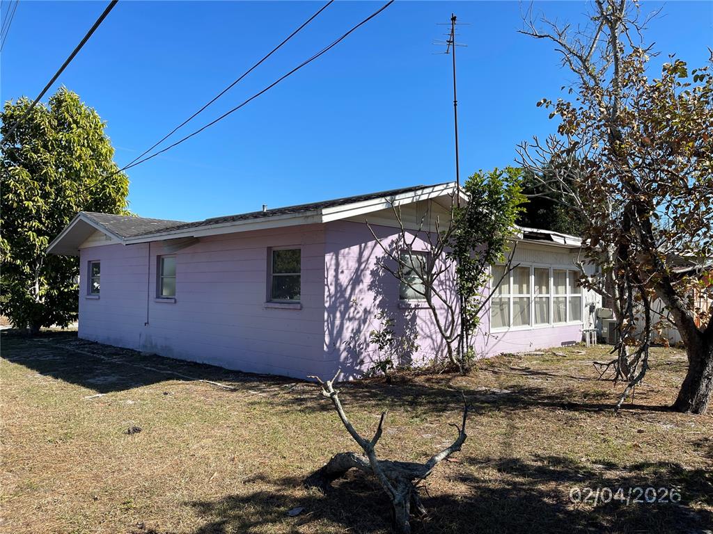 A single-story, light purple house with a screened-in porch stands on a grassy lot — 1708 CAMBRIDGE DRIVE, VENICE, FL