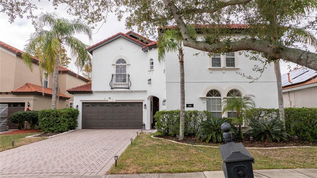 A two-story stucco house with a tile roof, a two-car garage, and a small balcony — 11410 RAPALLO LANE, WINDERMERE, FL