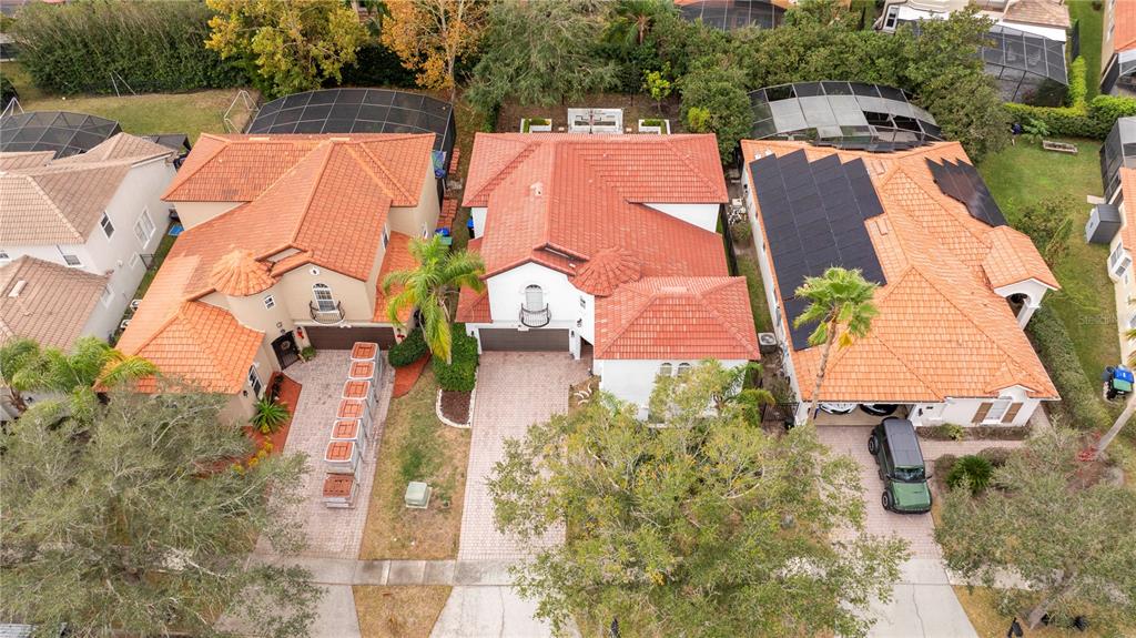 An aerial view shows three suburban houses with red tile roofs and paved driveways — 11410 RAPALLO LANE, WINDERMERE, FL