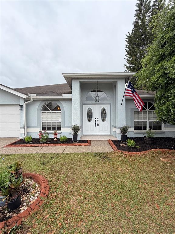 A single-story house with a light blue exterior, a two-car garage, and a front lawn — 1813 DOCKSIDE DRIVE, VALRICO, FL