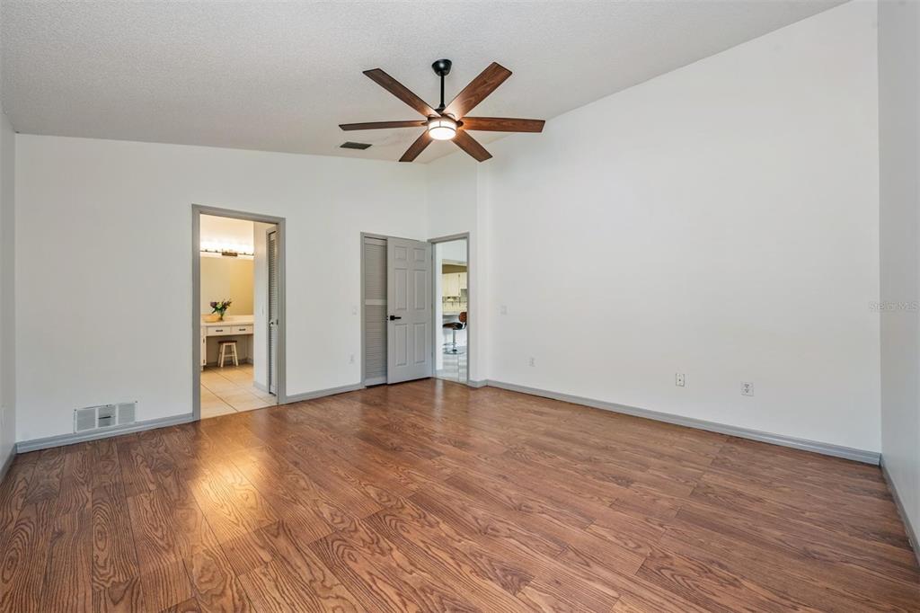 An empty bedroom features wood-look flooring, a ceiling fan, a window, and a doorway — 1813 DOCKSIDE DRIVE, VALRICO, FL
