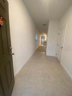 A long, narrow entryway with light-colored tile flooring leads toward an open living area — 2880 POPPY AVENUE, LAKE HAMILTON, FL