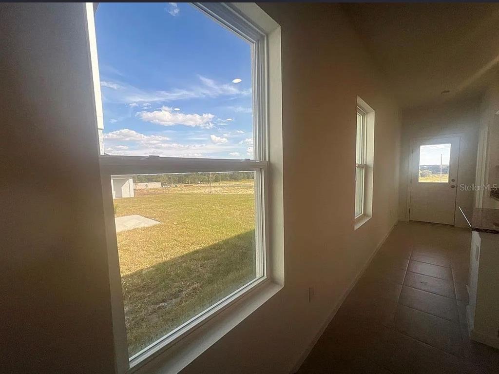 An interior view showing a hallway with tiled floors, two windows, and a door — 2880 POPPY AVENUE, LAKE HAMILTON, FL