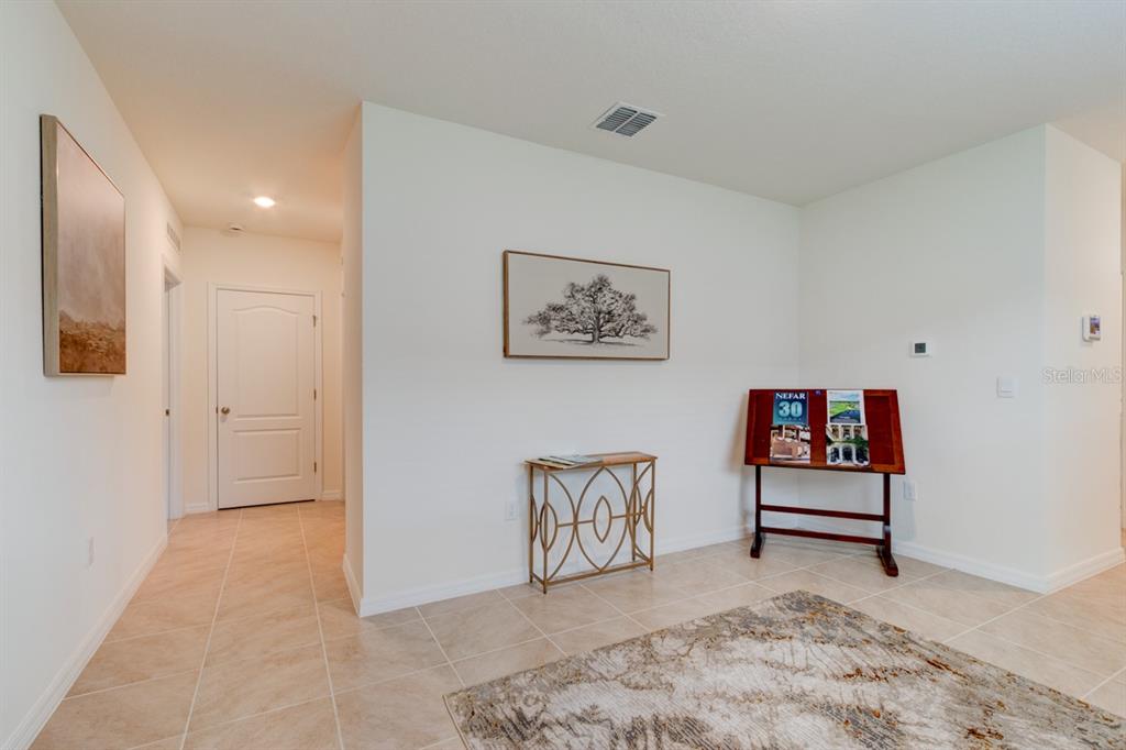 A tiled entryway features a console table, a display stand, and two framed wall pictures — 1360 CORK DRIVE, ORMOND BEACH, FL