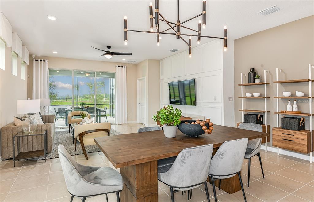 A dining area with a wooden table and chairs sits in front of a living room — 12506 ADOBE STREET, PARRISH, FL