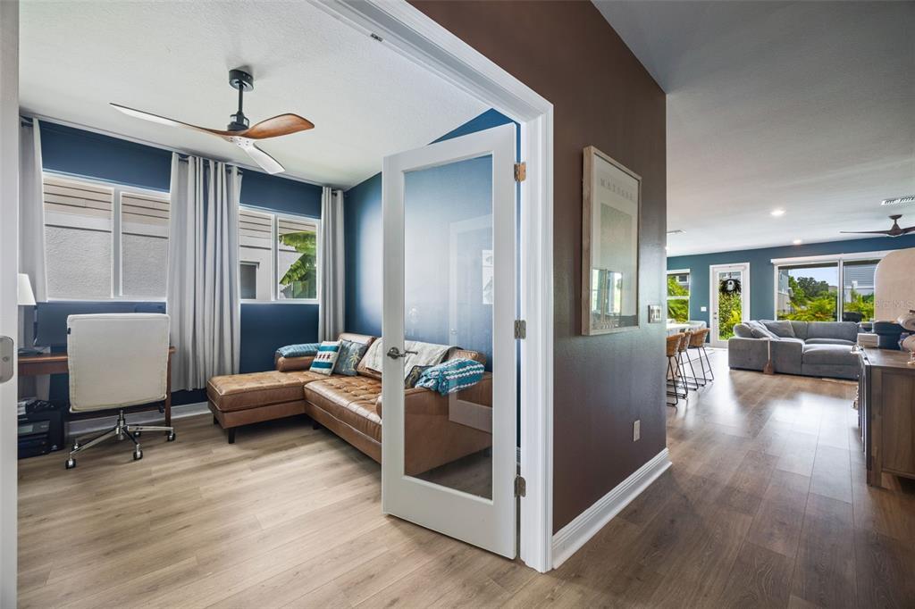 A home office with a leather sectional and desk connects to an open-concept living area — 11822 CHEVELON LANE, PARRISH, FL