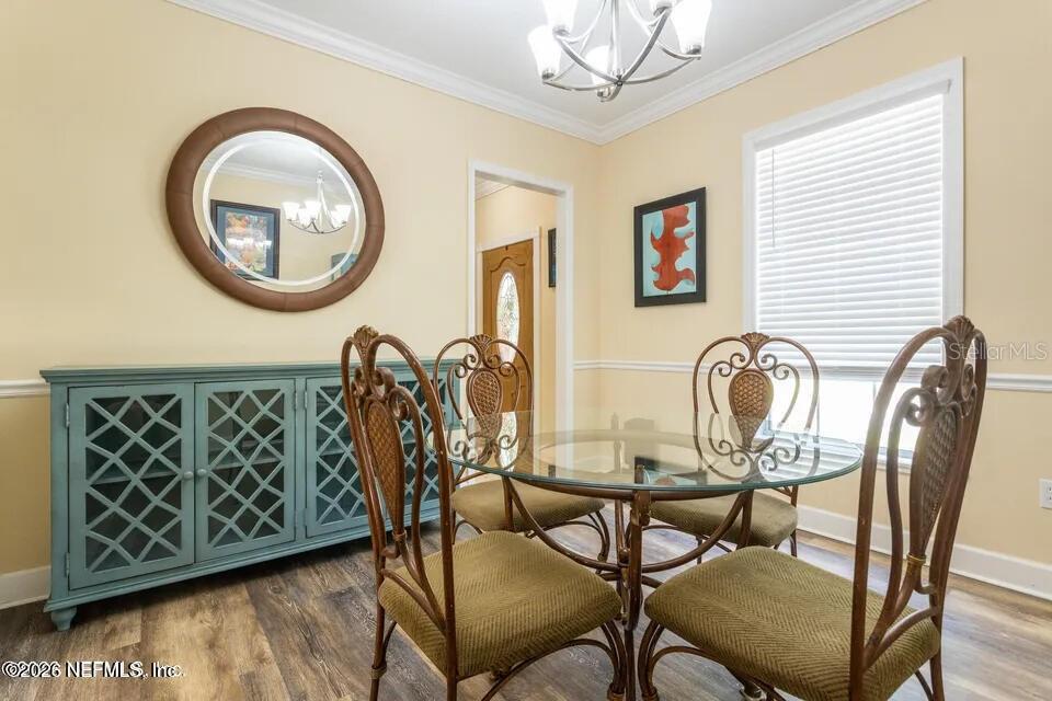 A dining room features a glass-topped table, four chairs, a blue sideboard, and a mirror — 168 HOUR GLASS CIRCLE, HAWTHORNE, FL