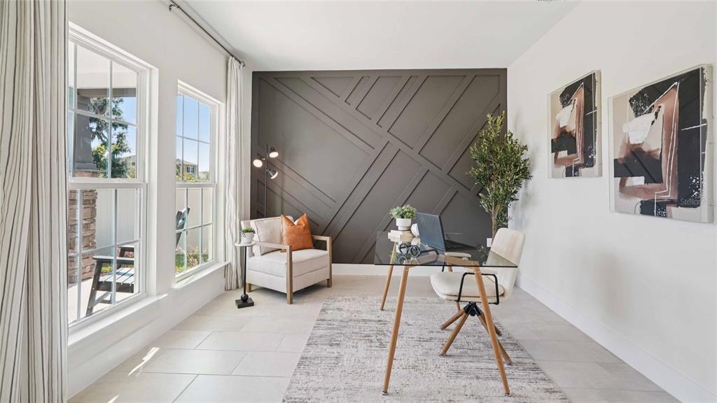 A home office features a dark geometric accent wall, a glass desk, and a reading chair — 11207 DUCKLING WAY, WEEKI WACHEE, FL