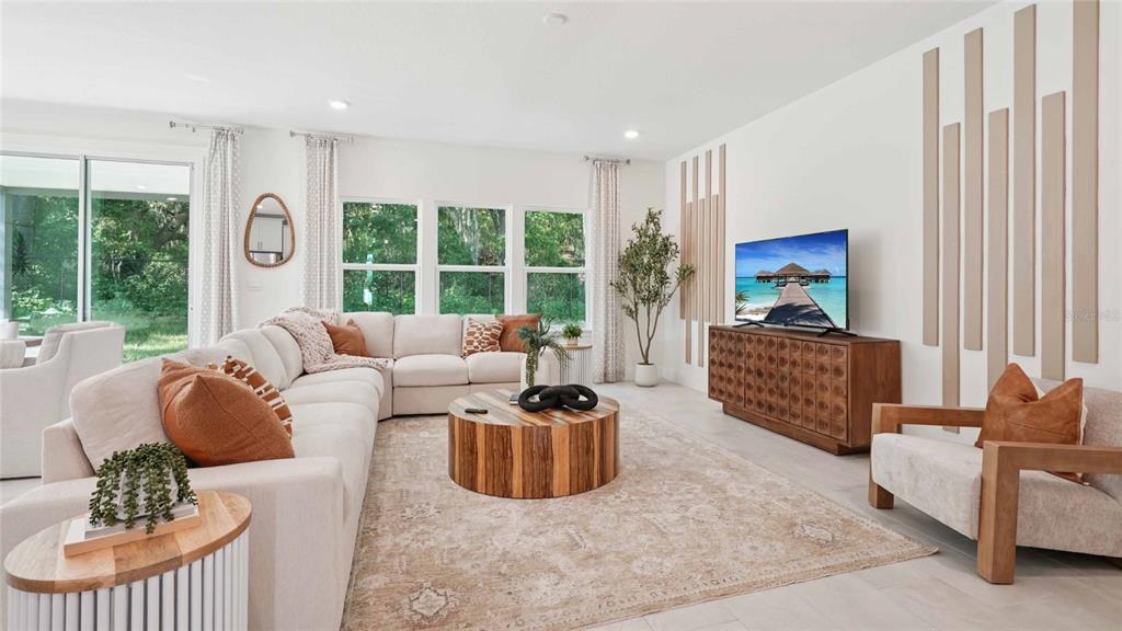 A bright living room features a large sectional sofa, wooden coffee table, and television console — 11207 DUCKLING WAY, WEEKI WACHEE, FL