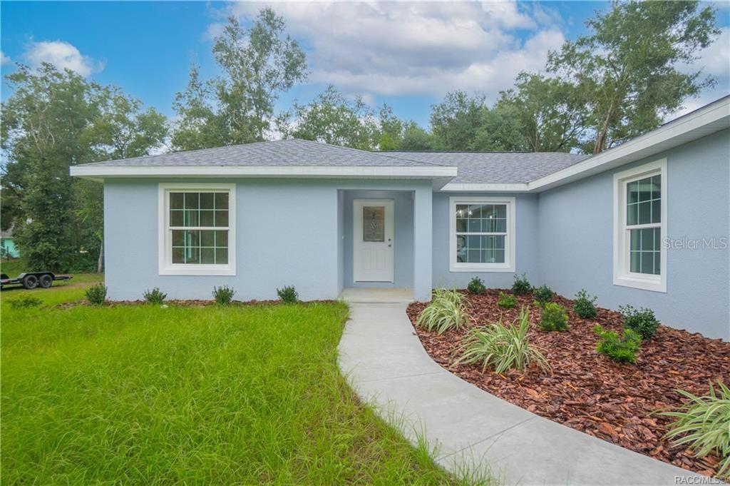 A light blue single-story house features a white front door and a concrete walkway — 3973 E DANO STREET, INVERNESS, FL