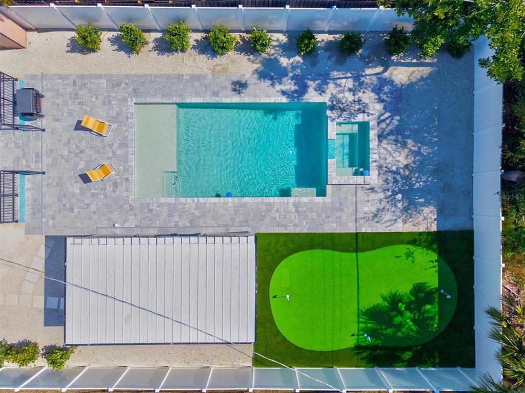 An aerial view shows a backyard with a swimming pool, spa, putting green, and patio — 2226 ARLINGTON STREET, SARASOTA, FL