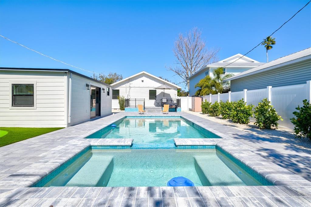 A backyard features a rectangular swimming pool with an attached spa and stone paver decking — 2226 ARLINGTON STREET, SARASOTA, FL