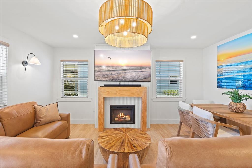 A living room features a fireplace, a television, leather sofas, and a round wooden table — 2226 ARLINGTON STREET, SARASOTA, FL