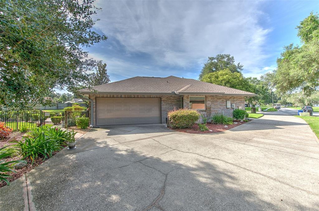 A single-story brick house with a two-car garage and a large concrete driveway — 2102 WHITLOCK PLACE, DOVER, FL