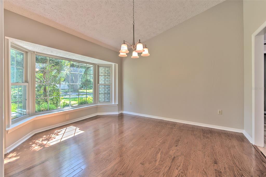 A dining room with hardwood floors, a bay window, and patterned wallpaper — 2102 WHITLOCK PLACE, DOVER, FL