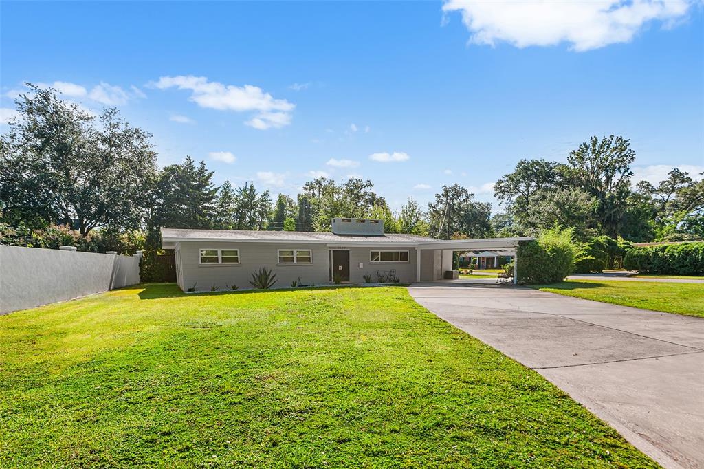 A single-story gray house with a flat roof, a concrete driveway, and a large lawn — 2624 EASTON TERRACE, LAKELAND, FL