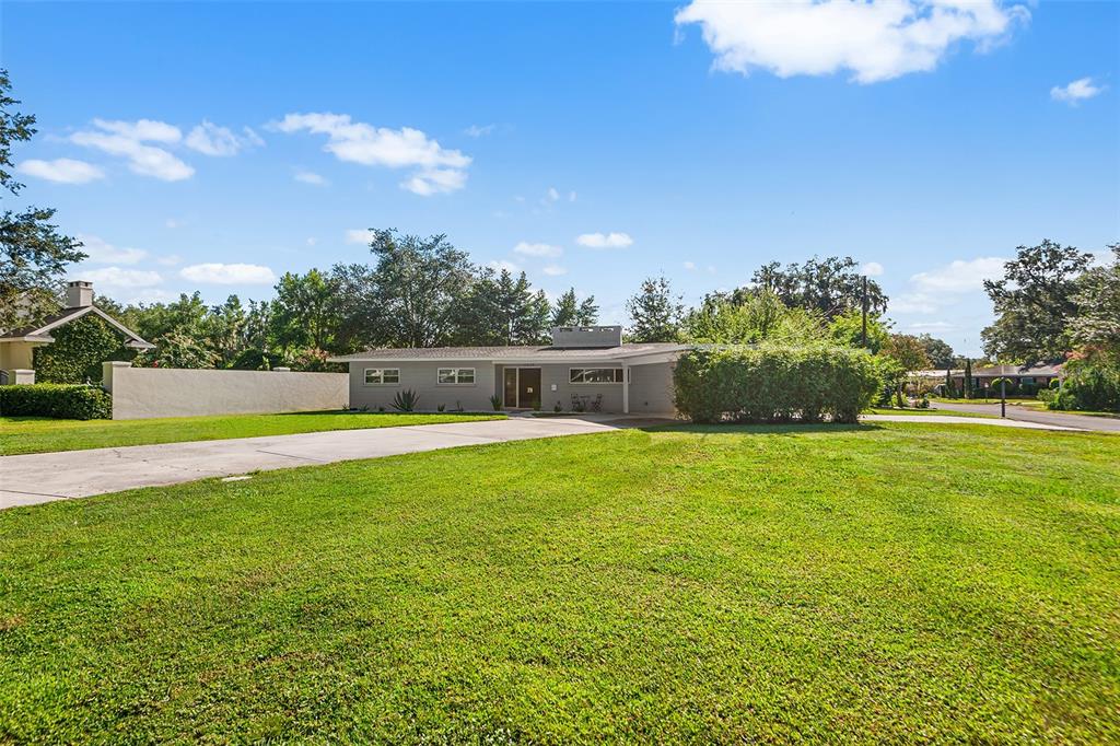 A single-story gray house with a flat roof and a large front lawn — 2624 EASTON TERRACE, LAKELAND, FL