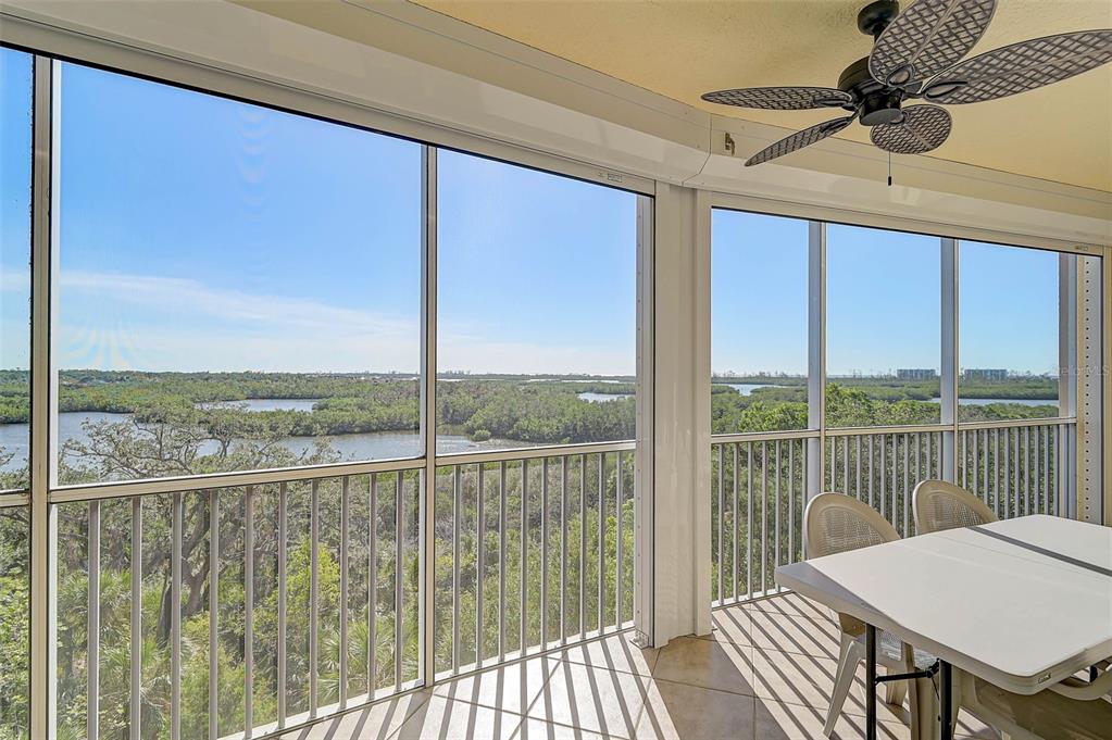 A screened-in balcony with tile flooring, a ceiling fan, and a view of the water — 3603 N POINT ROAD UNIT 602, OSPREY, FL
