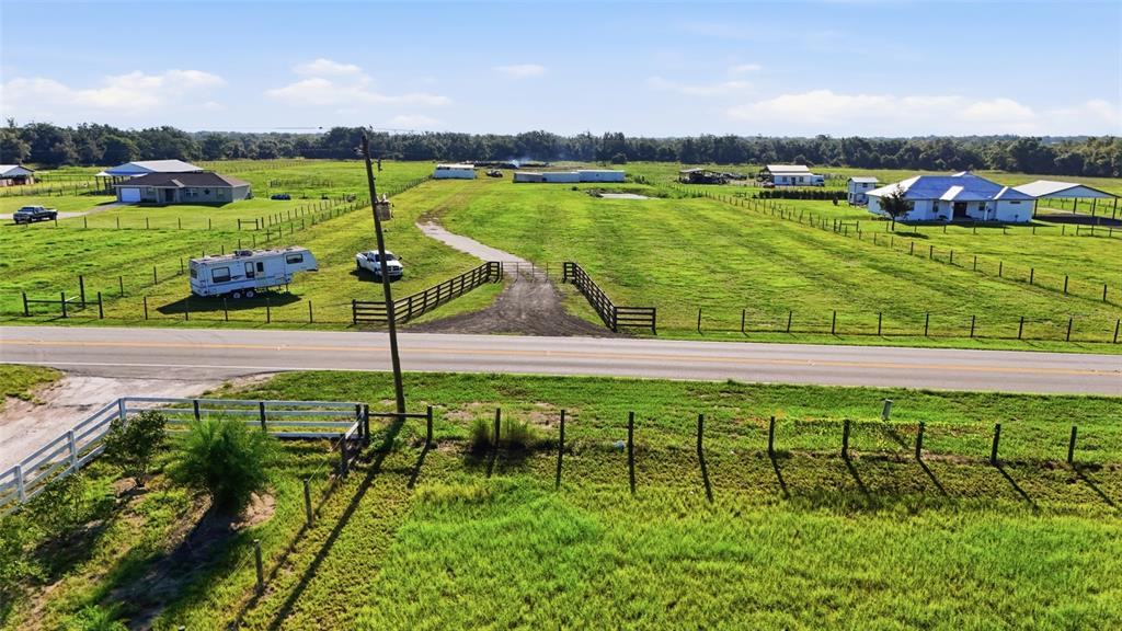 An aerial view shows a rural property with a house, outbuildings, and a fenced pasture — 3130 SE AIRPORT ROAD, ARCADIA, FL