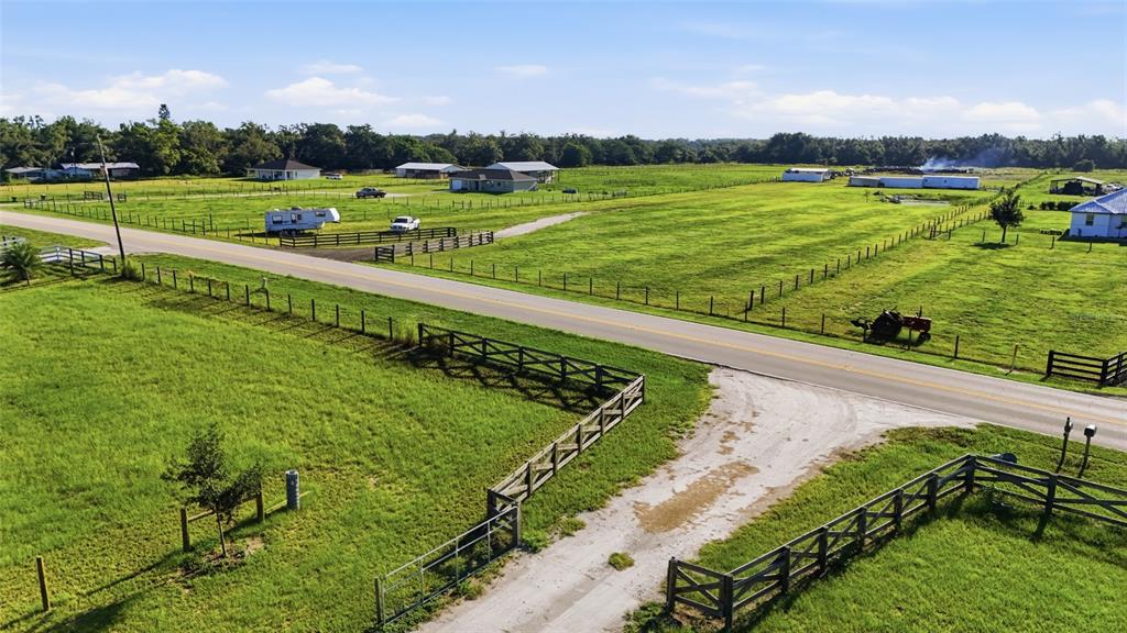 An aerial view shows a rural property with fenced pastures, a road, and several buildings — 3130 SE AIRPORT ROAD, ARCADIA, FL