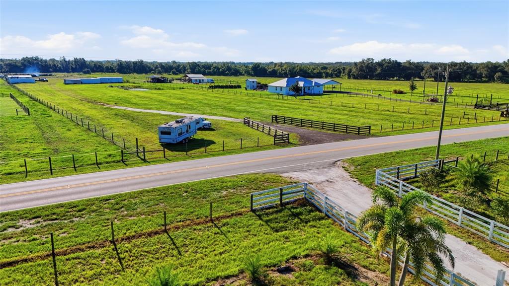 An aerial view shows a rural property with a house, outbuildings, and a parked camper — 3130 SE AIRPORT ROAD, ARCADIA, FL
