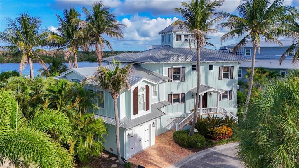 An aerial view shows a multi-story coastal house with a metal roof and palm trees — 13310 ANGLERS WAY, PLACIDA, FL