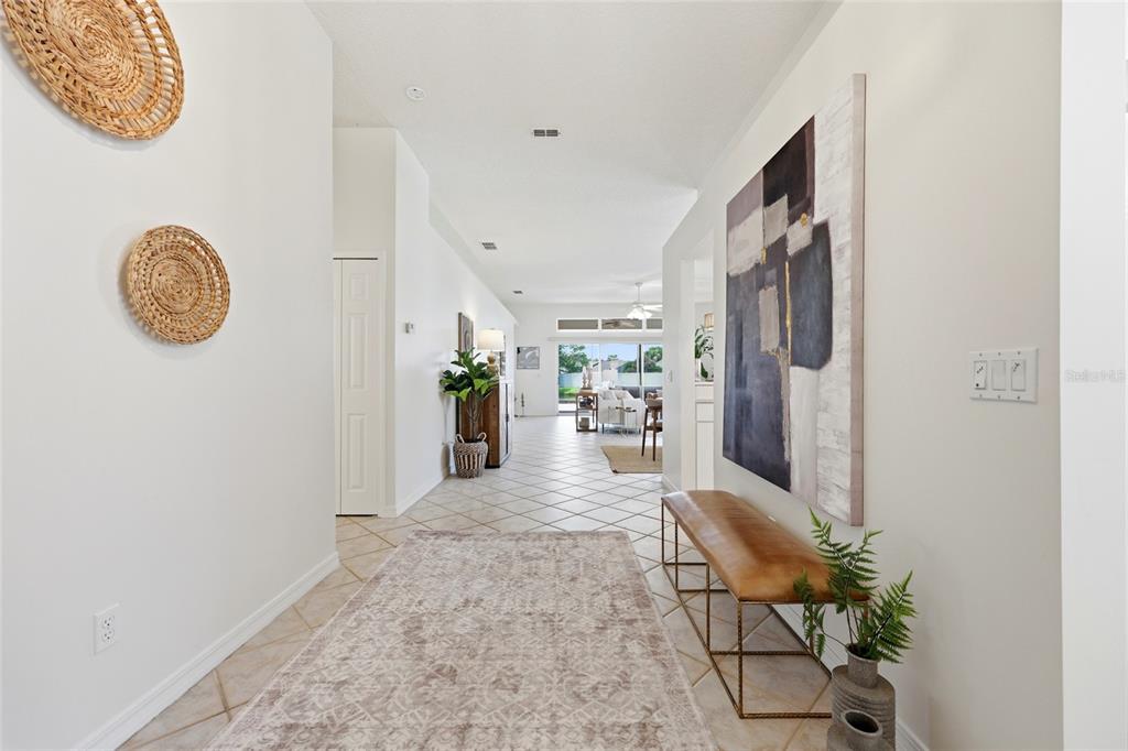 A bright entryway features a long rug, a leather bench, and large abstract wall art — 272 SEA WOODS DRIVE N, ST AUGUSTINE, FL