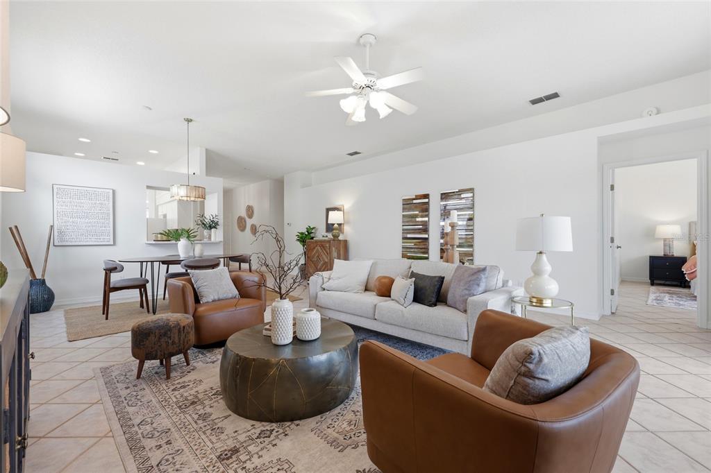 A living room features a white sofa, two leather armchairs, and a round metal coffee table — 272 SEA WOODS DRIVE N, ST AUGUSTINE, FL