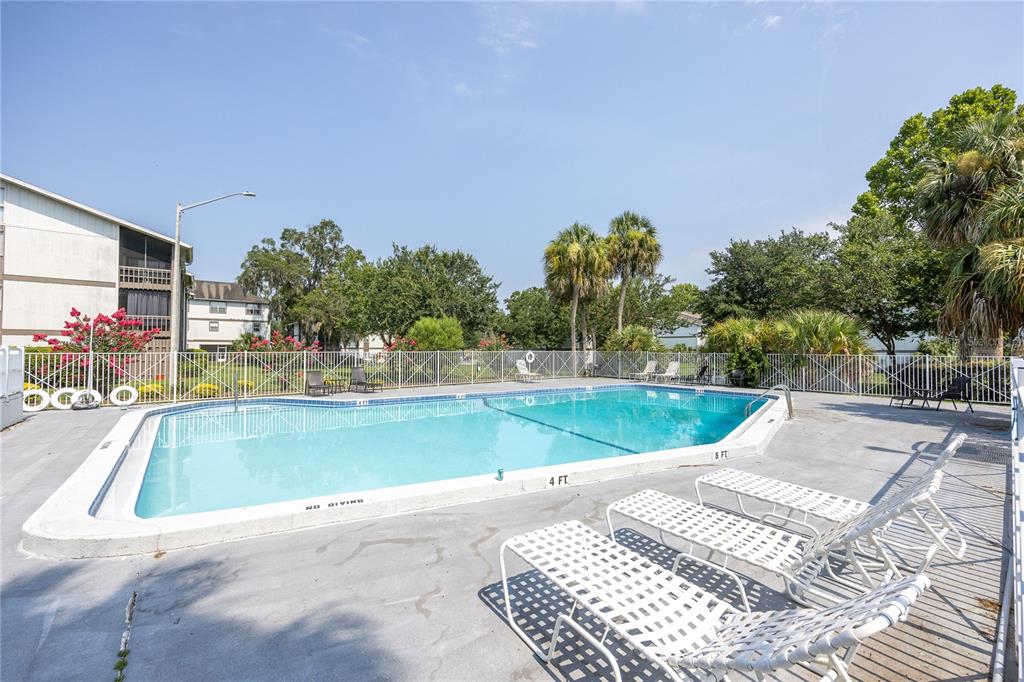 An empty room features gray walls, wood-look flooring, and a sliding glass door to a balcony — 6519 W NEWBERRY ROAD UNIT 812, GAINESVILLE, FL