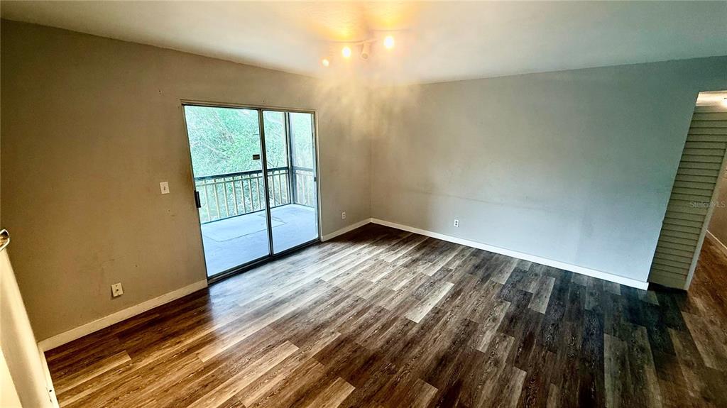 A galley kitchen features wood cabinets, laminate countertops, a white stove, and a white refrigerator — 6519 W NEWBERRY ROAD UNIT 812, GAINESVILLE, FL