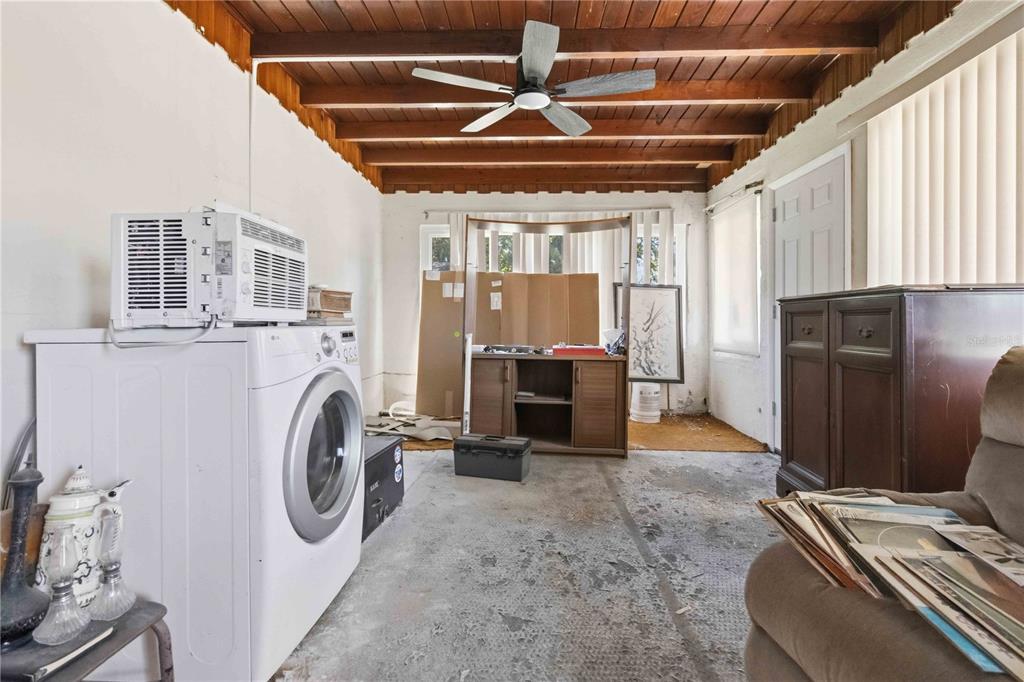 A laundry area with a washing machine, exposed wood ceiling beams, and a ceiling fan — 214 BLAKE AVENUE, COCOA, FL