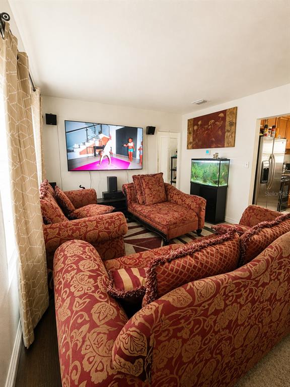 A living room features patterned red furniture, a wall-mounted television, and an aquarium — 1740 S RIO GRANDE AVENUE, ORLANDO, FL