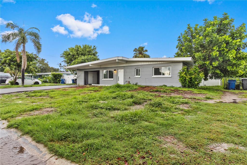 A single-story gray house with a flat roof sits on a grassy lot — 5711 21ST STREET W, BRADENTON, FL