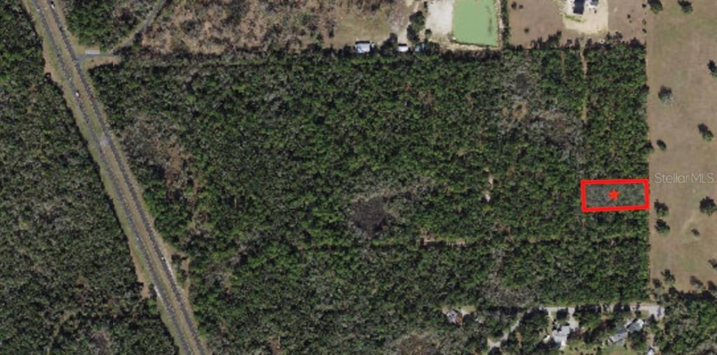 An aerial view shows a rectangular plot of land highlighted with a red border and star — 5099 N WHETSTONE POINT, CRYSTAL RIVER, FL