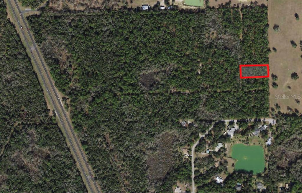 An aerial view shows a rectangular plot of land outlined in red within a wooded area — 5099 N WHETSTONE POINT, CRYSTAL RIVER, FL