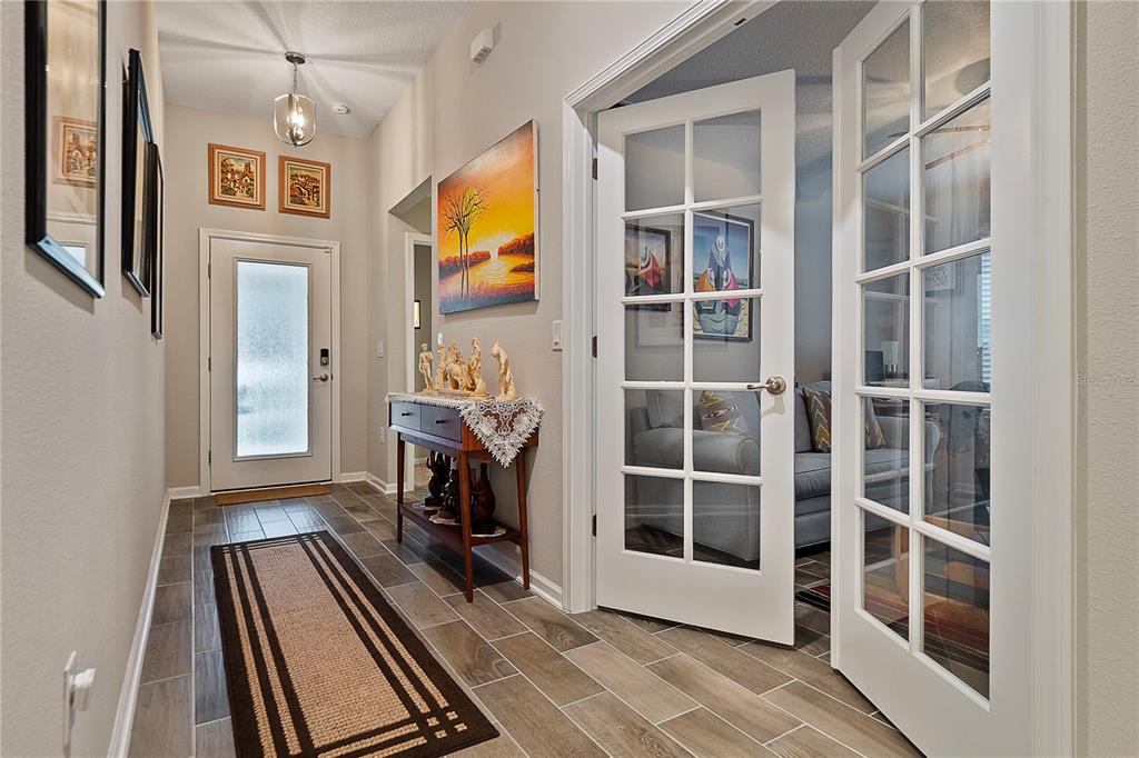 A tiled entryway features a console table, a runner rug, and French doors to a room — 285 OSPREY LANDING LANE, ST AUGUSTINE, FL