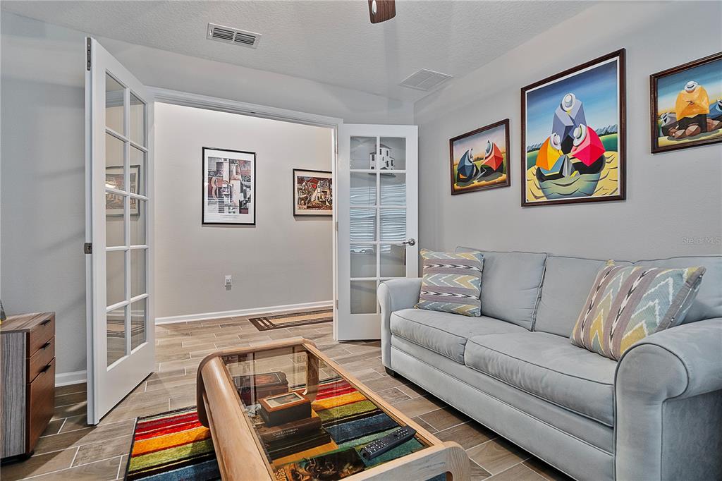 A living room features a light blue sofa, a glass coffee table, and framed wall art — 285 OSPREY LANDING LANE, ST AUGUSTINE, FL