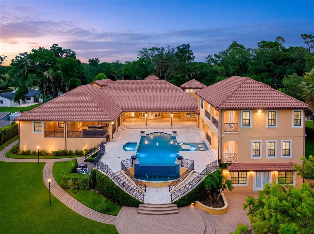An aerial view of a large house with a tiled roof and a central swimming pool — 1795 W LAKE MARY BOULEVARD, LAKE MARY, FL